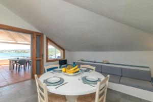 a dining room with a white table with bananas on it at Vista Playa 1 in Isola di Porticciuolo