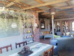 a dining room with a table and a stove at Hawklee Country House in Nottingham Road