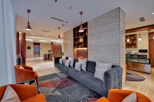 卡卡纳德Clarion Hotel Khayal Kochi, Infopark的客厅配有长沙发和橙色椅子