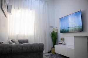 a living room with a couch and a flat screen tv at Luxe cozy home in Dar es Salaam
