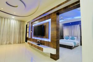 een slaapkamer met een bed en een televisie aan de muur bij BLACK FOREST Villa mahabaleshwar in Mahabaleshwar