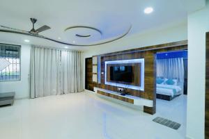 Mahalaxmi Hills في ماهاباليشوار: غرفة معيشة فيها تلفزيون على جدار