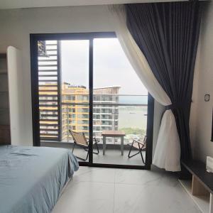 a bedroom with a bed and a balcony with a view at Căn hộ Beverly Vinhomes grand park Q9 - An Trú Homestay in Gò Công