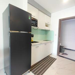 a kitchen with a black refrigerator in a room at Căn hộ Beverly Vinhomes grand park Q9 - An Trú Homestay in Gò Công