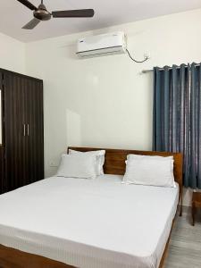Un dormitorio con una cama y un ventilador de techo. en Elite Homes Perfect Guest Rooms.., en Visakhapatnam