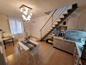 a kitchen and dining room with a table and a staircase at La Casina Lungomare di Fabi Livorno in Livorno +40 photos