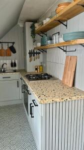 a kitchen with white cabinets and a counter top at Luxury coastal retreat - On-site parking - sleeps 4 in Ilfracombe +6 photos