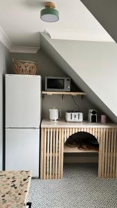 a kitchen with a refrigerator and a table with a microwave at Luxury coastal retreat - On-site parking - sleeps 4 in Ilfracombe