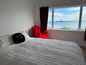 布拉夫海边小屋的一间卧室配有一张带红色椅子的床和窗户