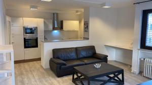 a living room with a leather couch and a table at Neu renovierte Whg nähe Wasserbahnhof und Krankenhaus mit Aufzug Große Küche in Mülheim an der Ruhr