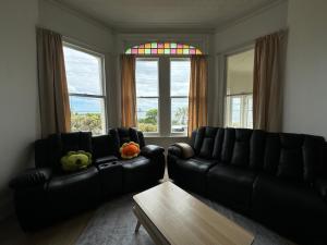 布拉夫海边小屋的客厅里有两张黑色皮沙发和一张桌子
