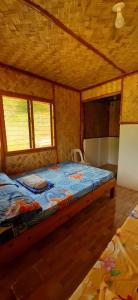 een slaapkamer met een bed in een houten kamer bij Manga's swimming pool in El Nido
