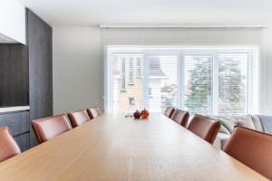 a conference room with a large wooden table and chairs at Elegant Coastal Retreat in Knokke-Heist in Knokke-Heist