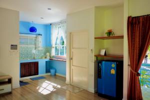 a kitchen with blue walls and a blue refrigerator at Baan Sarika Phusuan in Nakhon Nayok
