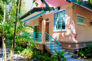 a house with a blue railing and a porch at Baan Sarika Phusuan in Nakhon Nayok