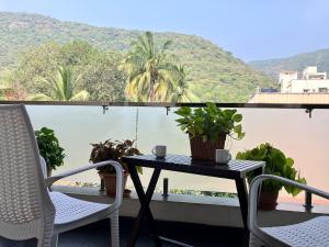 Una mesa y sillas en un balcón con vista. en Elite Homes Perfect Guest Rooms.., en Visakhapatnam