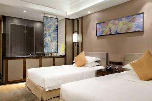 Postel nebo postele na pokoji v ubytování Ramada Foshan Hotel