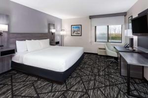 a hotel room with a large bed and a desk at La Quinta Inn by Wyndham Cleveland Independence in Independence