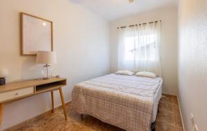 a bedroom with a bed and a desk and a window at 3 Bedroom Cozy Apartment In Torrevieja in Torrevieja