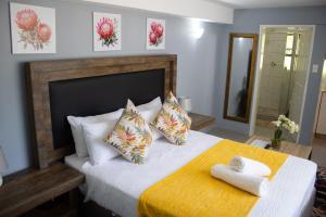 LobambaRehoboth Ezulwini Suites的一间卧室，床上有两条毛巾
