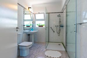 a bathroom with a shower toilet and a sink at Casa Flora, 2 quartos,vista mar in Arco da Calheta +26 photos