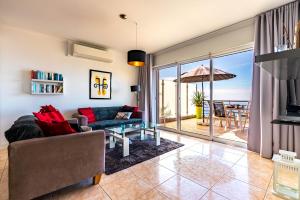 a living room with a couch and a view of the ocean at Casa Flora, 2 quartos,vista mar in Arco da Calheta
