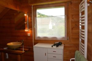 a bathroom with a sink and a window at Chalet sous Le Théâtre in Bussang +19 photos
