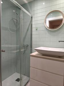 une salle de bain avec une douche en verre et un lavabo dans l'établissement Vicaria, à Gijón