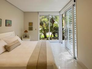 a bedroom with a bed and a sliding glass door at Casa Bella - Deslumbrante c/Enxoval - Riviera Md 5 in Riviera de São Lourenço +82 photos