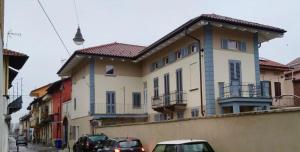 a building with cars parked in front of it on a street at airport apartments piano terra in San Maurizio Canavese
