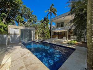 a swimming pool in the backyard of a house at Casa Bella - Deslumbrante c/Enxoval - Riviera Md 5 in Riviera de São Lourenço