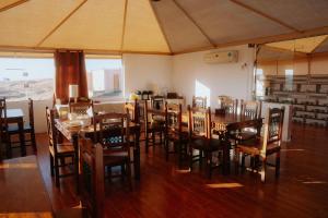 a dining room with a large table and chairs at Silent Dunes Camp in Ḩawīyah