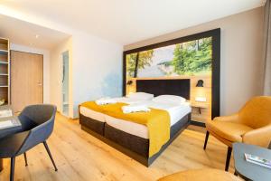 a bedroom with a large bed and two chairs at Parkhotel Rügen in Bergen auf Rügen