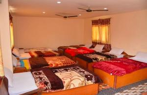 a room with four beds in a room at Sauraha Inn in Sauraha