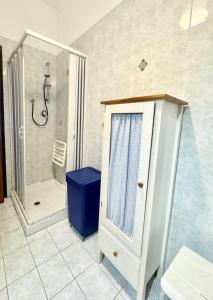 a bathroom with a shower and a blue trash can at Casa Dante in Finale Ligure +18 photos