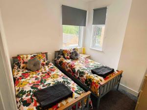 ein Schlafzimmer mit zwei Betten und einem Fenster in der Unterkunft Modern, renovated 3 bed home near railway station in North Ferriby