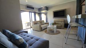a living room with a couch and a tv at Cabanas Del Mar 32 in Kingsburgh