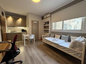 a bedroom with a bed and a desk and a kitchen at Work from home Project in Thessaloniki