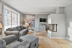 Una sala de estar con un sofá y una chimenea. en Reetdachhaus Reetkoje Reetdachhaus Reetkoje I, en Süderhöft