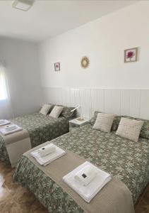 a hotel room with two beds and two tables at Villa Alarilla Grupos Grandes in Fuentidueña de Tajo +19 photos