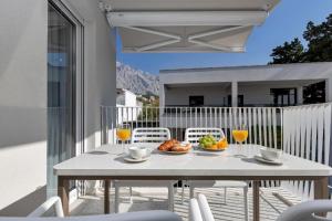 a table with food and drinks on a balcony at Villa Anchor in Baška Voda