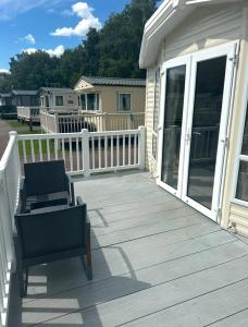 a wooden deck with a chair and sliding glass doors at The Meadows in Tattershall