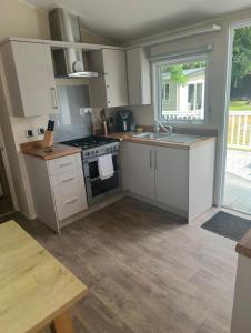 a kitchen with white cabinets and a stove top oven at The Meadows in Tattershall