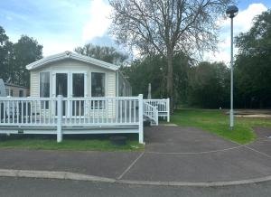 a small white house with a white fence at The Meadows in Tattershall +4 photos