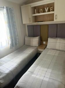 two beds in a small room with a window at The Meadows in Tattershall