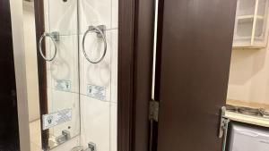 Un baño con ducha con puerta de cristal. en فندق رشيد الفضي, en Al Hindāwīyah