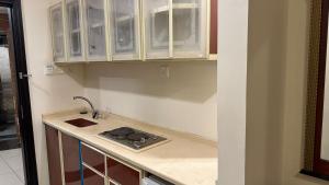 Una cocina con gabinetes blancos y un fregadero. en فندق رشيد الفضي, en Al Hindāwīyah