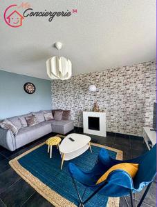 Spacieux T3 Standing Parking privé centre ville Montpellier في مونبلييه: غرفة معيشة مع أريكة وطاولة وكراسي