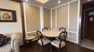 a room with a table and chairs and a couch at Chanakya Hotel, Patna in Patna