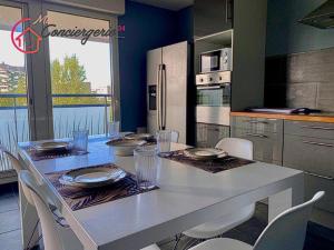 Spacieux T3 Standing Parking privé centre ville Montpellier في مونبلييه: مطبخ مع طاولة مع كراسي وثلاجة +7 صور